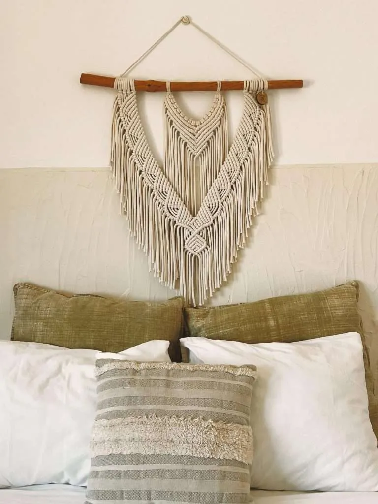 Painel de macramé por cima de uma cama, feito à mão na Ericeira